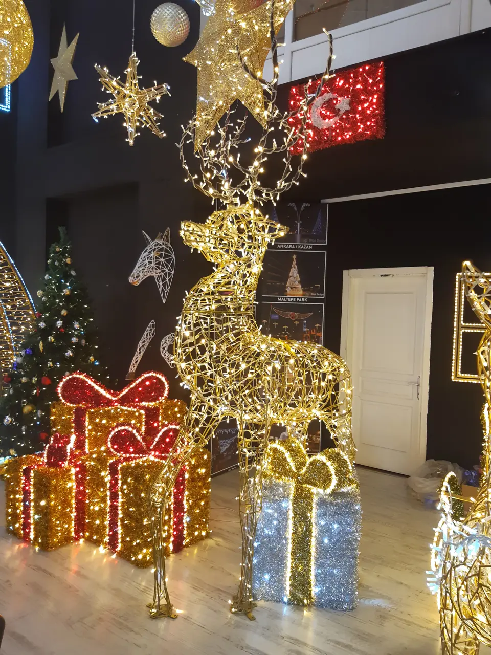 Kırmızı ve gümüş ışıklı hediye paketleri ile altın ışıklı geyik