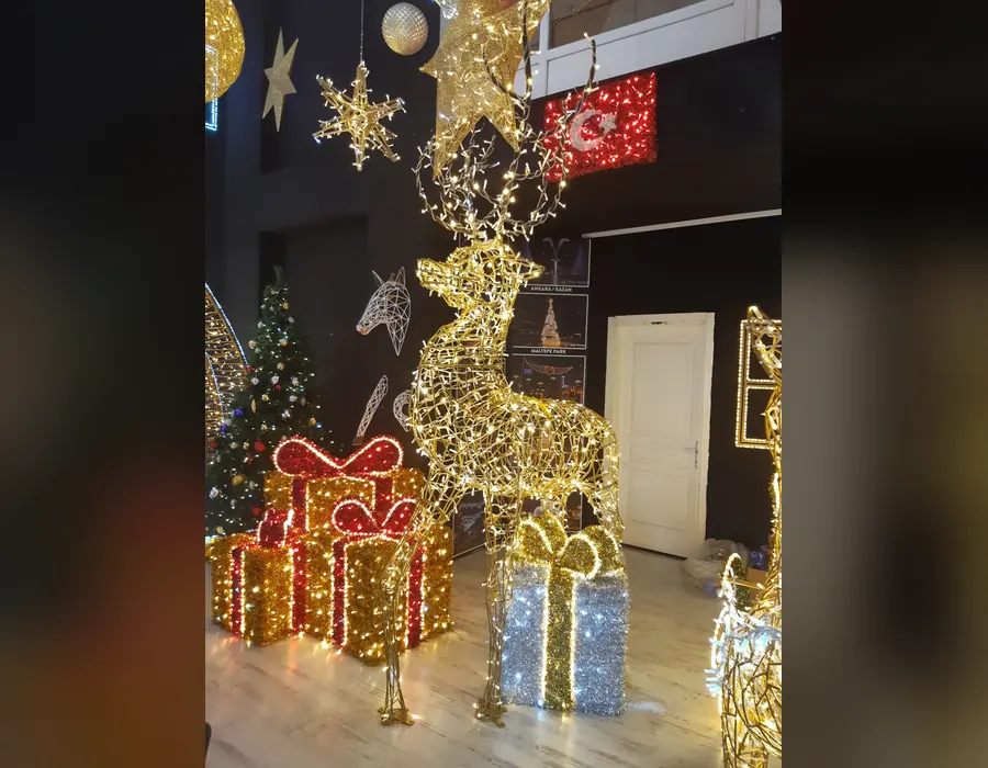 Kırmızı ve gümüş ışıklı hediye paketleri ile altın ışıklı geyik